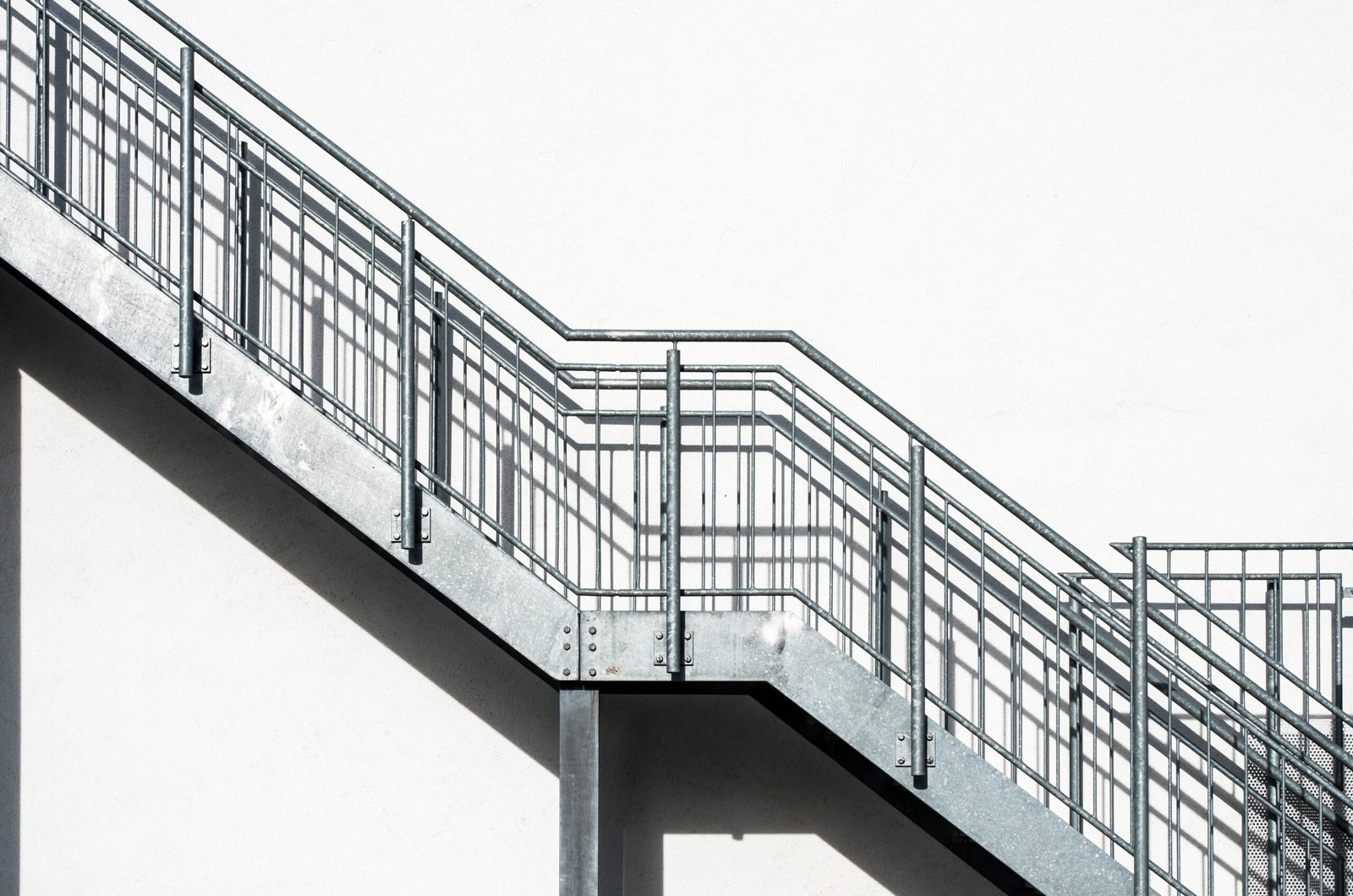 Metal stairs on a white building wall